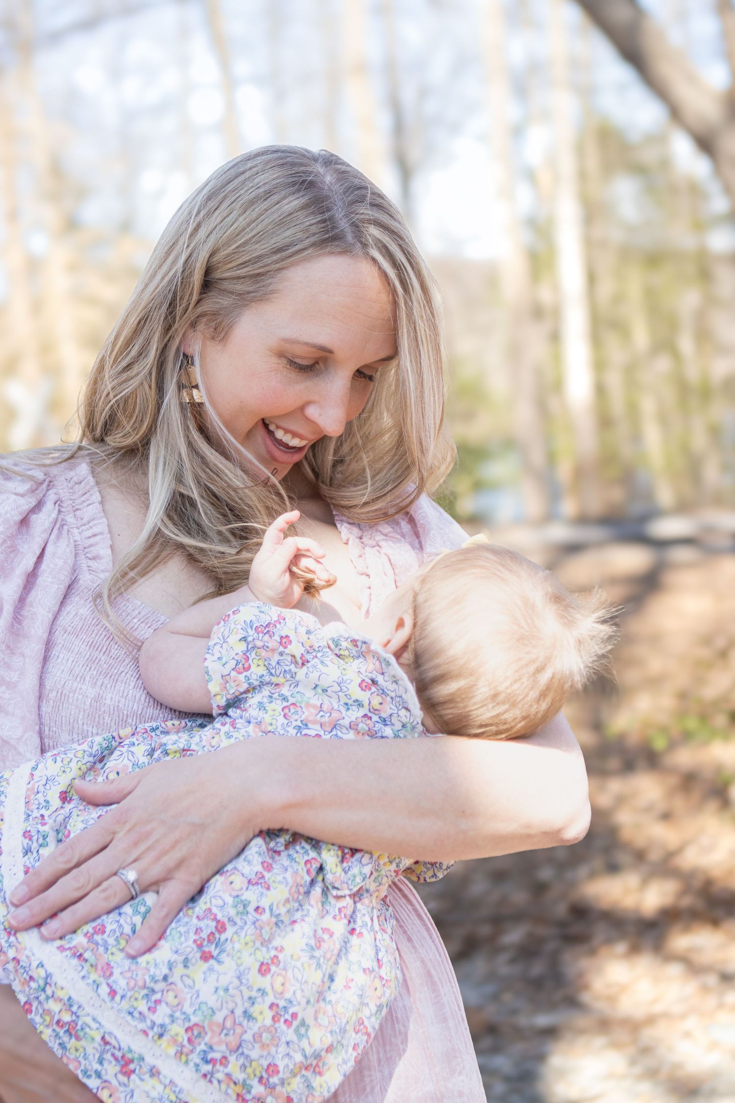 Tender moment captured between parent and child in sunny spring woodland setting.