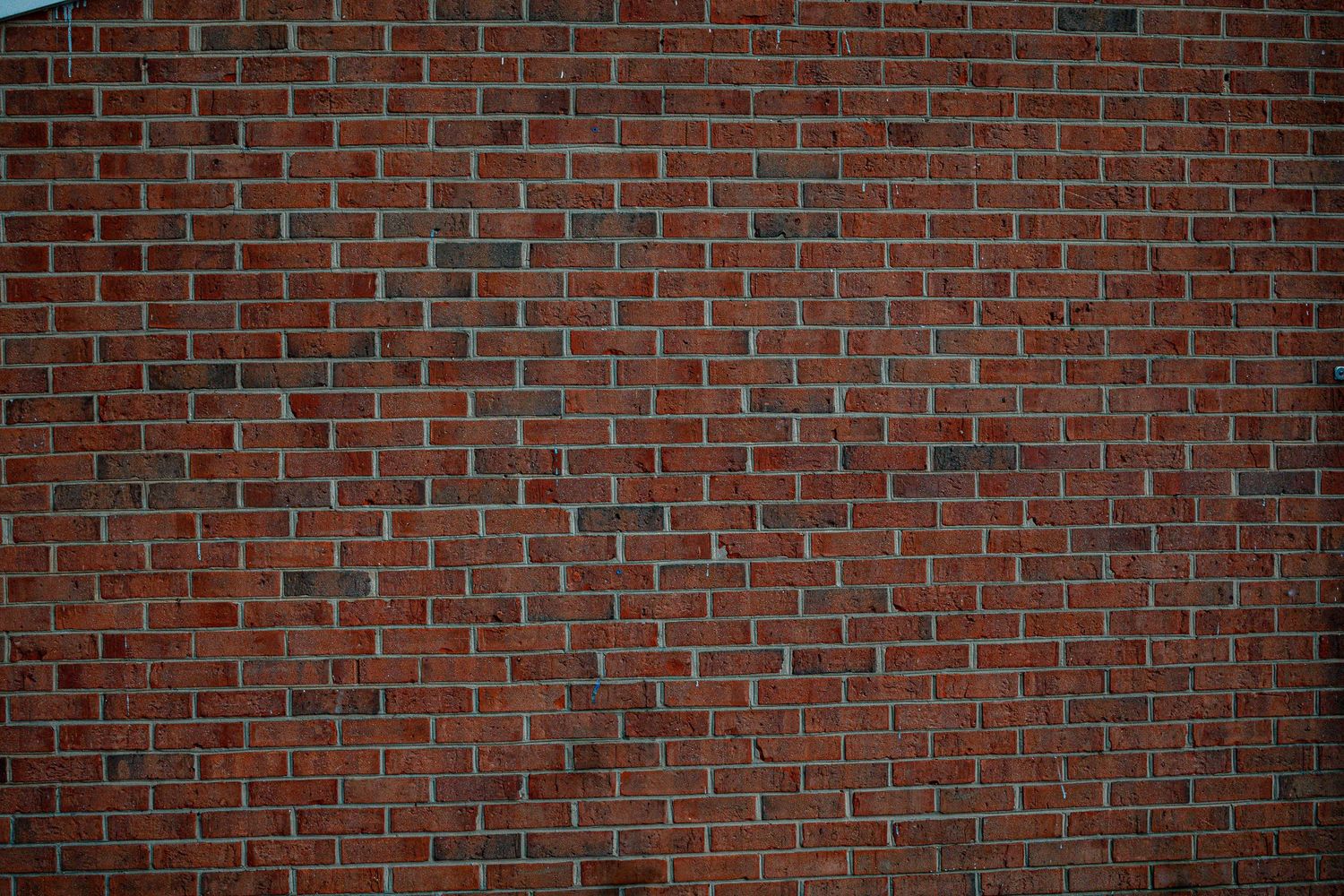 Red brick wall texture background with staggered pattern and weathered mortar joints.