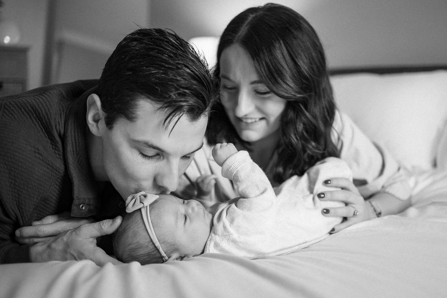 Black and white romantic photos showing tender intimate moments between a couple in bed.
