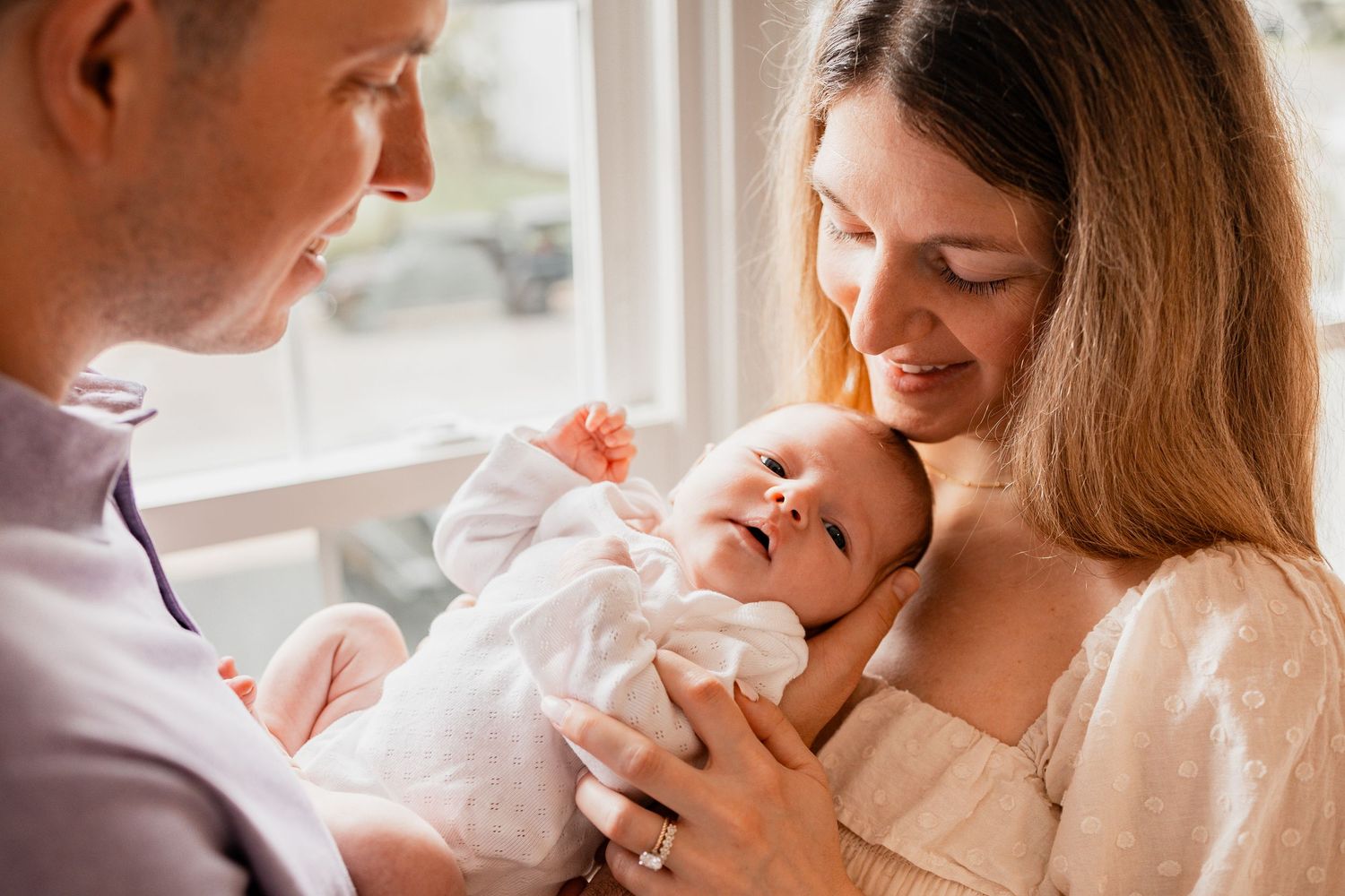 Tender moments between parent and newborn baby shown in a series of soft, intimate photographs.