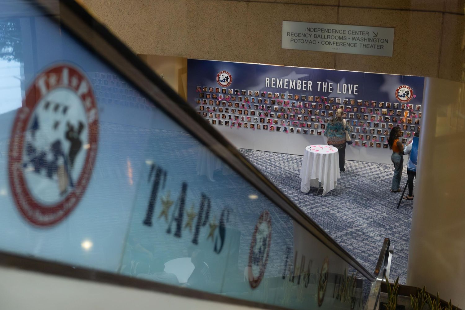 TAPS memorial event with Remember The Love wall display honoring fallen military heroes in a ceremonial hall.