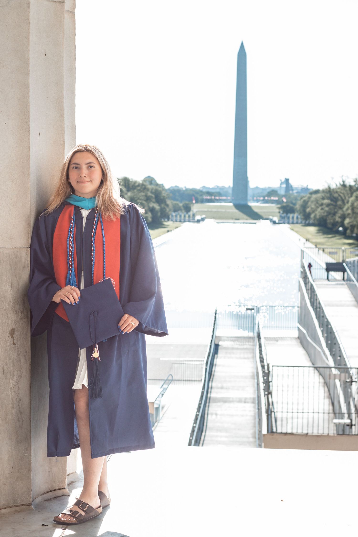 Navy blazer and red scarf outfit styled against Jefferson Memorial backdrop with Washington Monument visible.