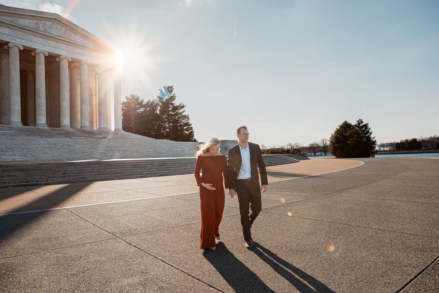 Couple walking hand in hand at the Jefferson Memorial in Washington D.C. on a sunny day.