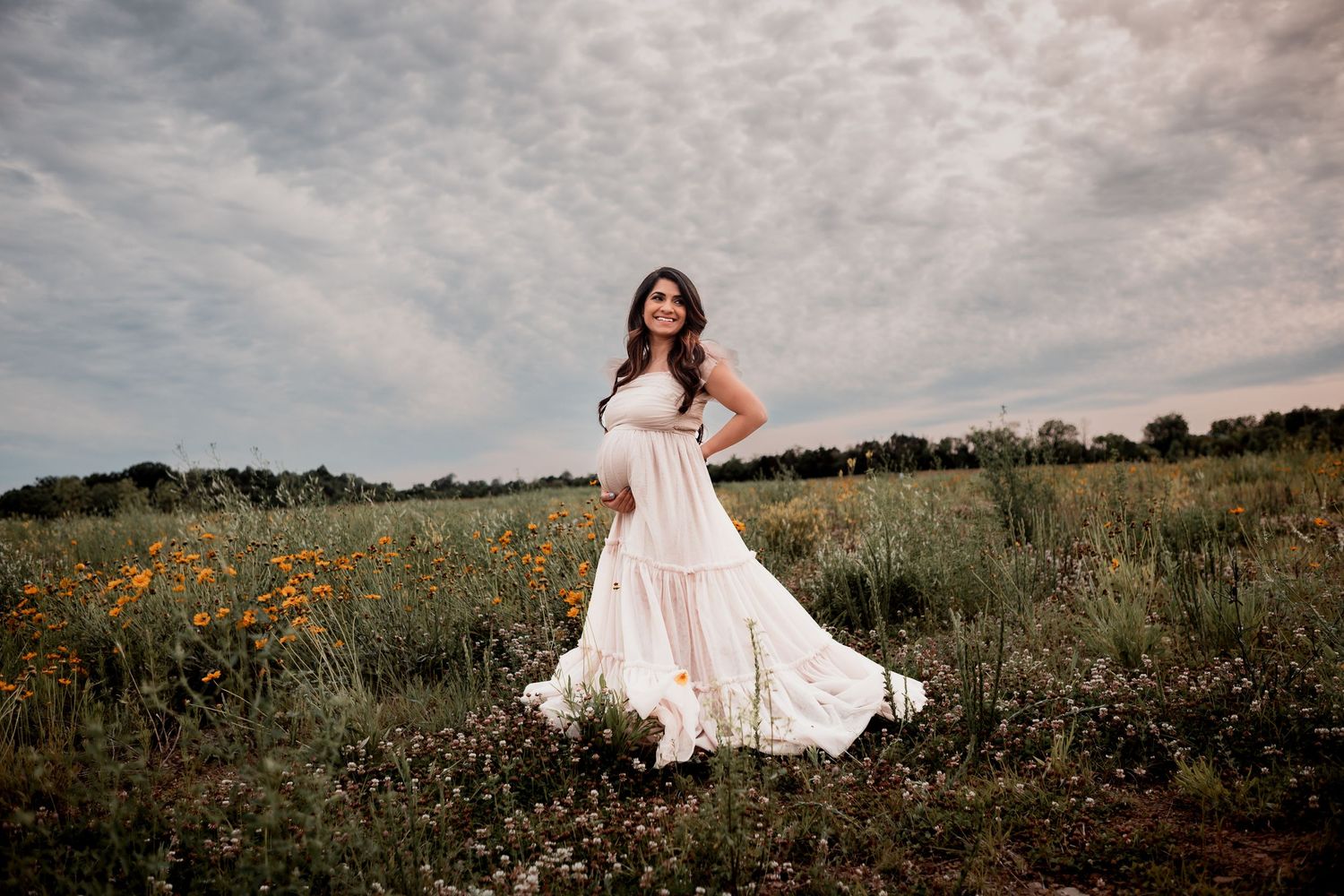 A flowing white maxi dress twirls in a wildflower meadow at sunset, creating a romantic summer scene.