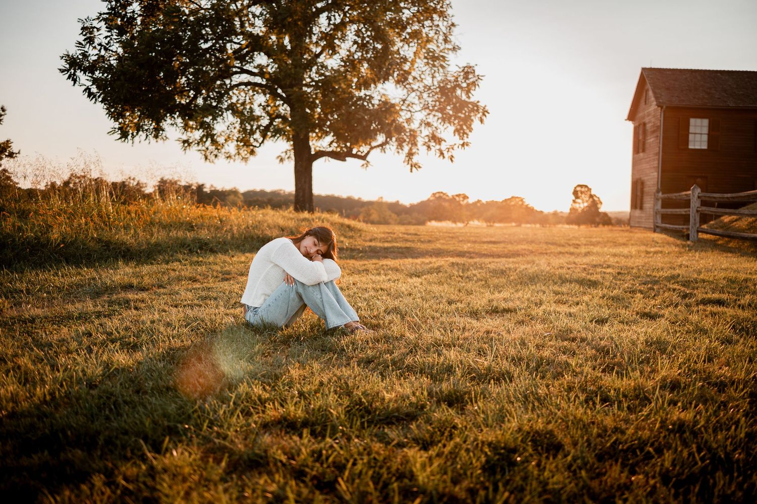 A romantic sunset photoshoot in a golden wheat field shows a couple embracing amidst warm autumn light.