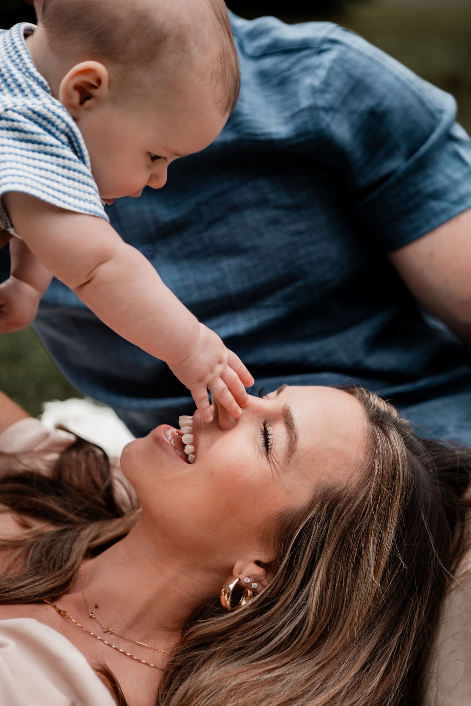 A tender moment between parent and child as they play and laugh together outdoors.