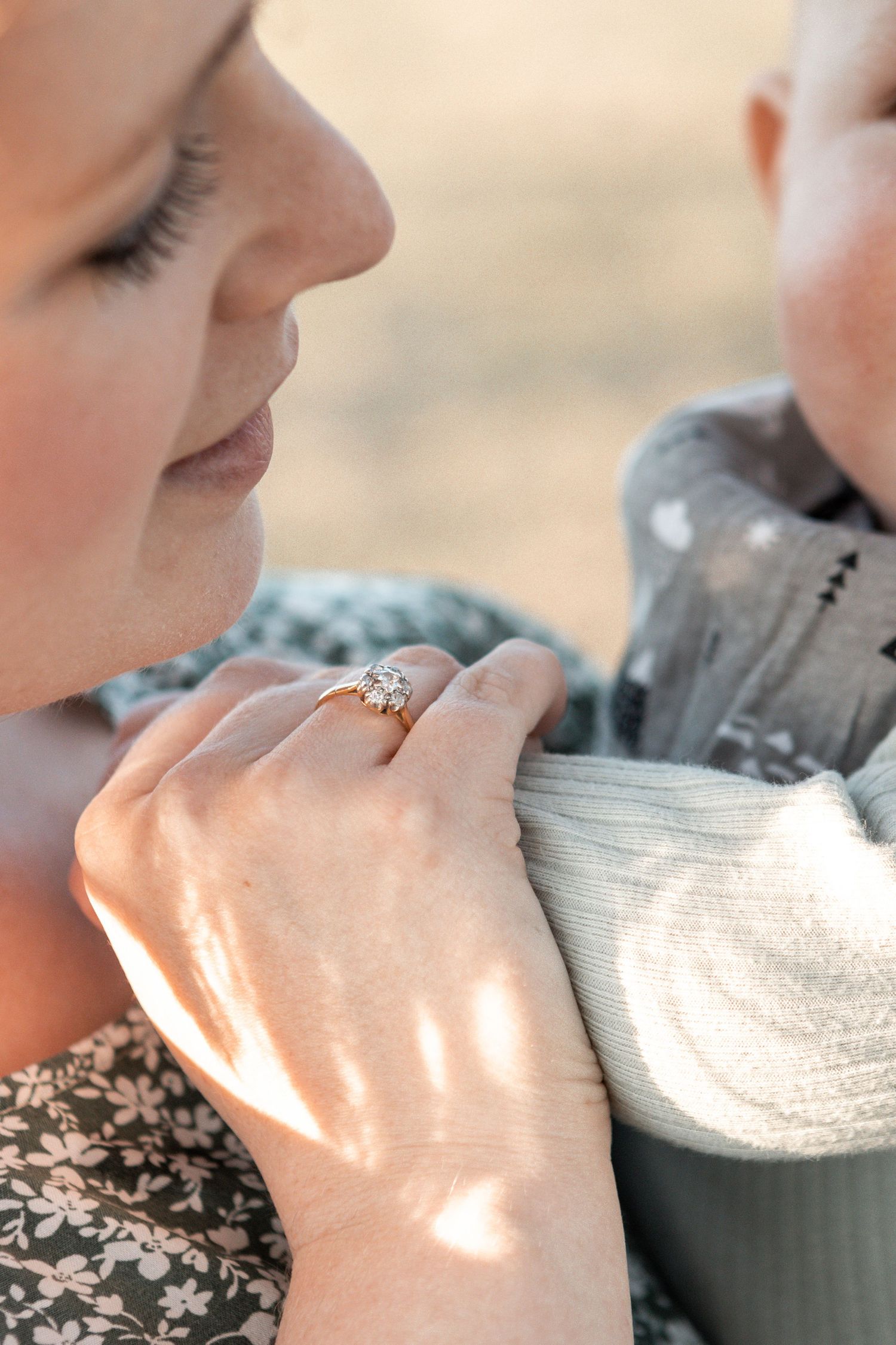 Close-up detail of hands gently embracing during an intimate outdoor moment.
