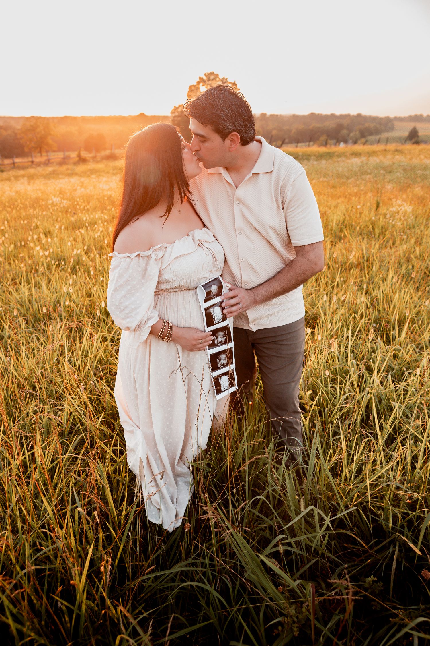 A couple shares a tender moment in a golden wheat field at sunset.