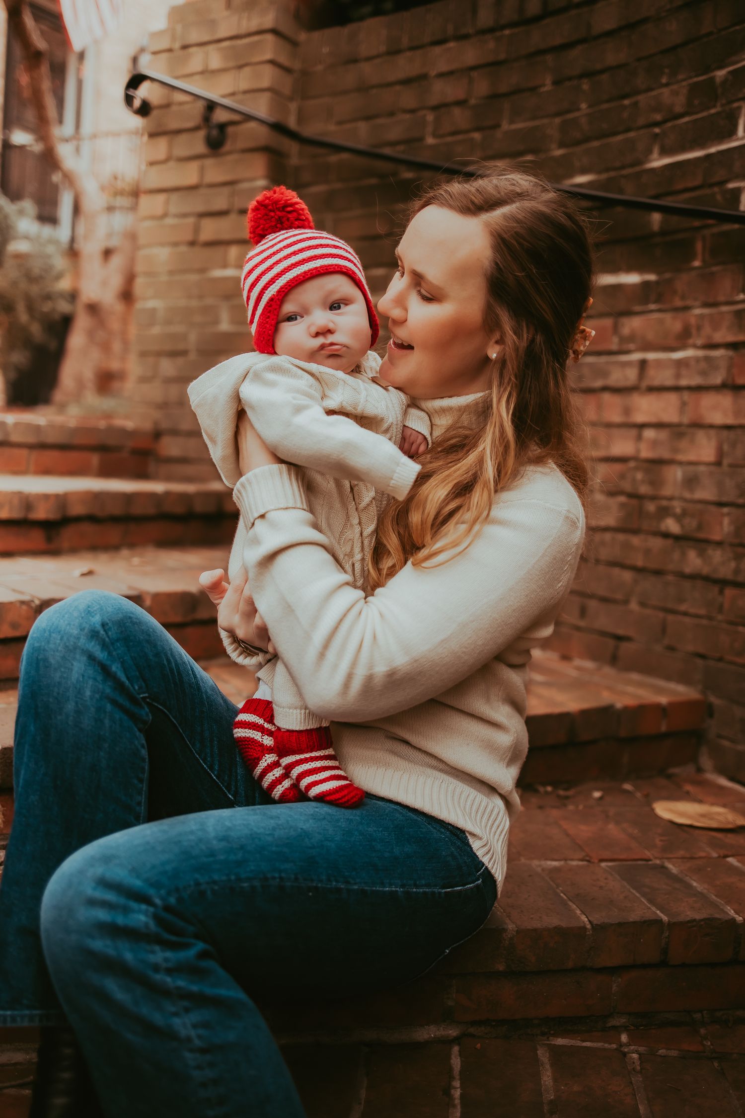A series of tender moments captured against a brick wall backdrop as a parent shares affectionate moments with a small child.