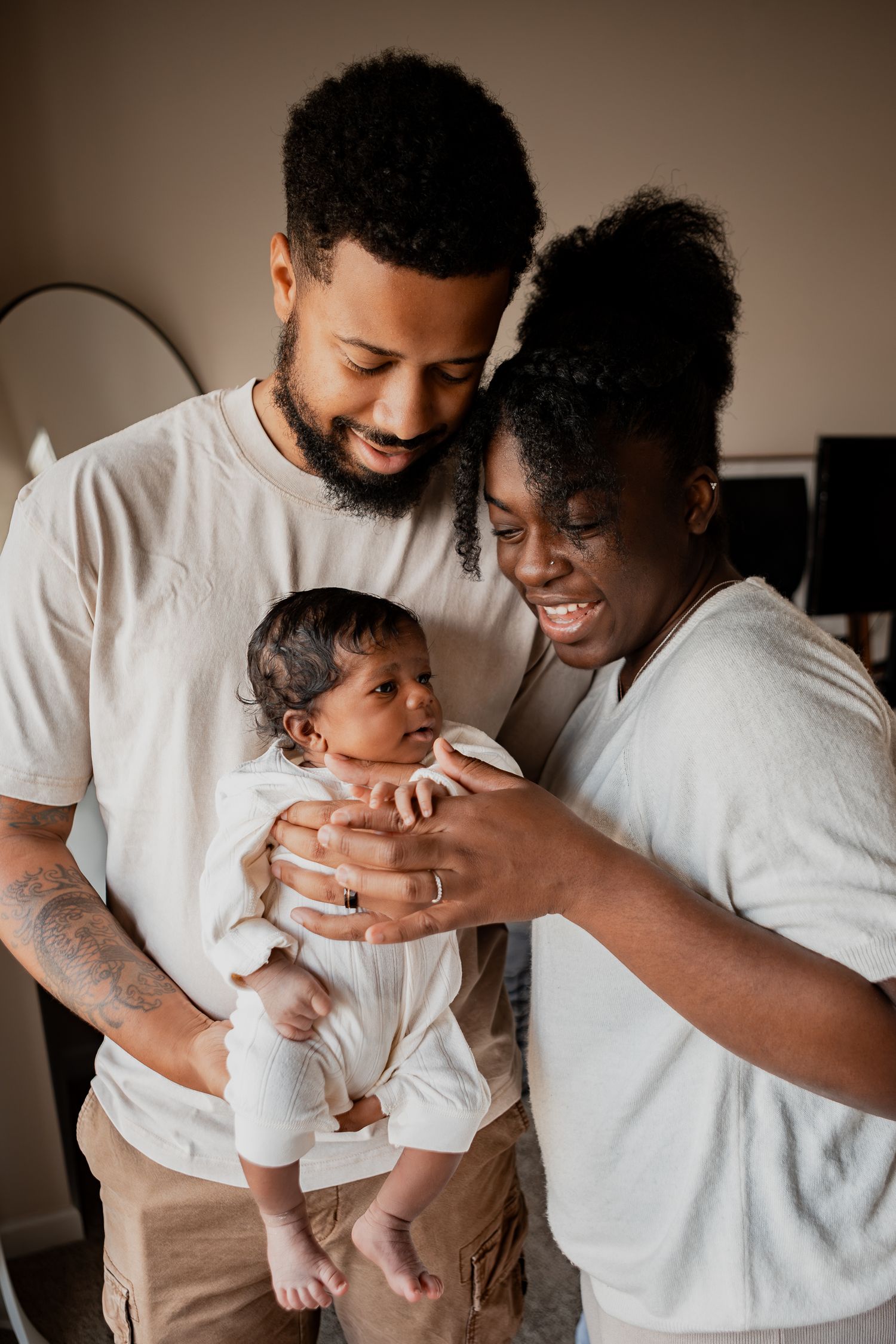 A heartwarming sequence of parents in white shirts sharing joyful moments with their infant.