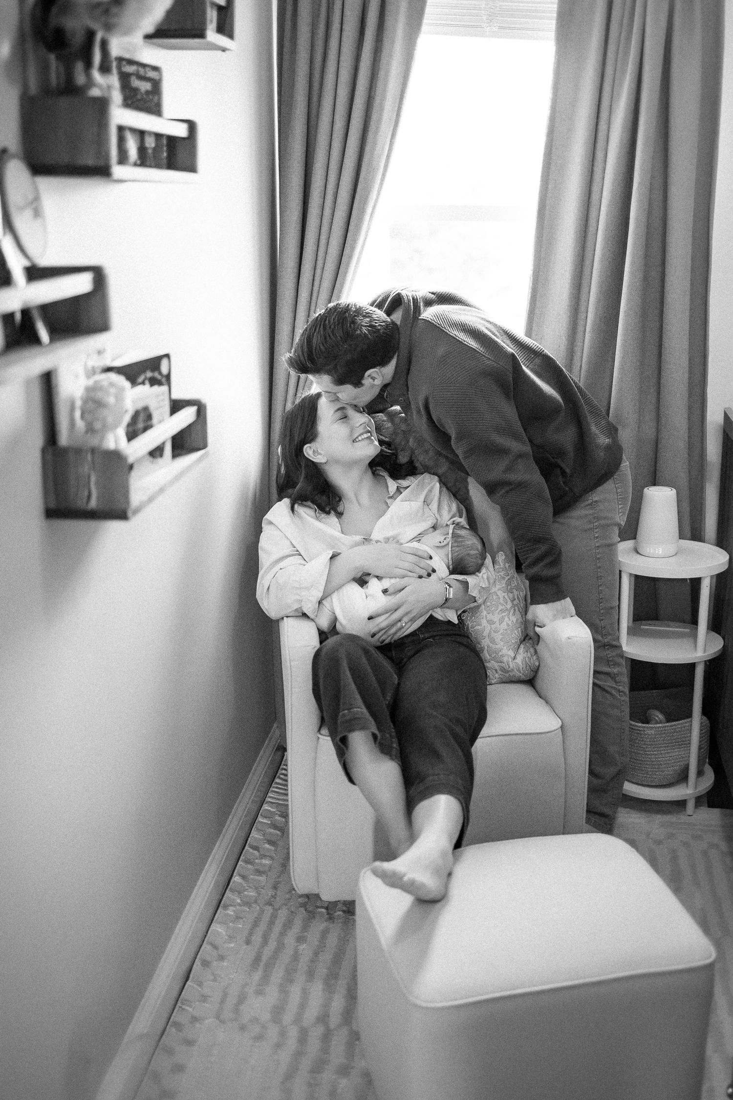 Black and white photos showing playful interaction on a chair by a window.