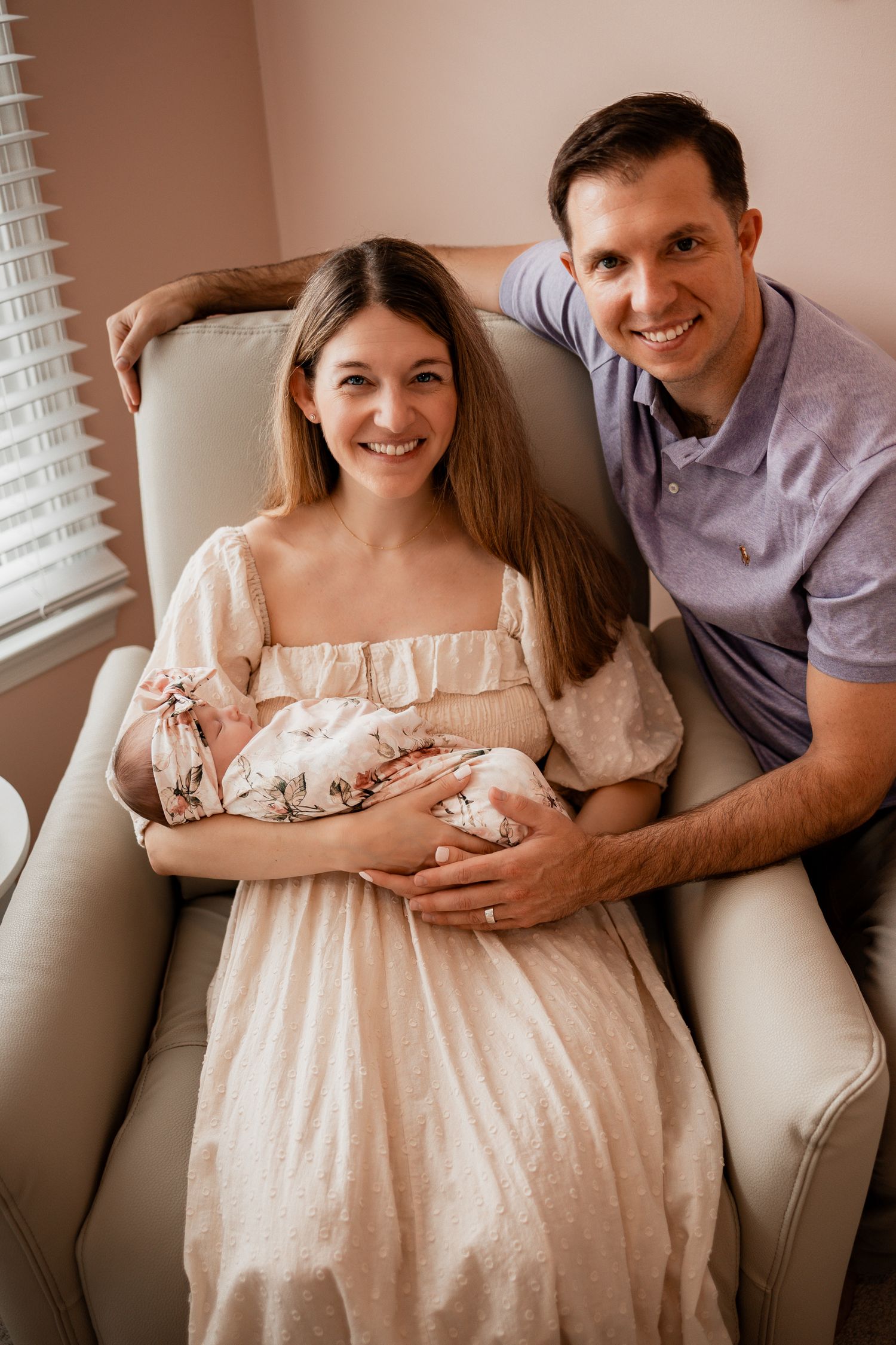 Family portrait series on a cream couch showing intimate moments with their newborn baby.