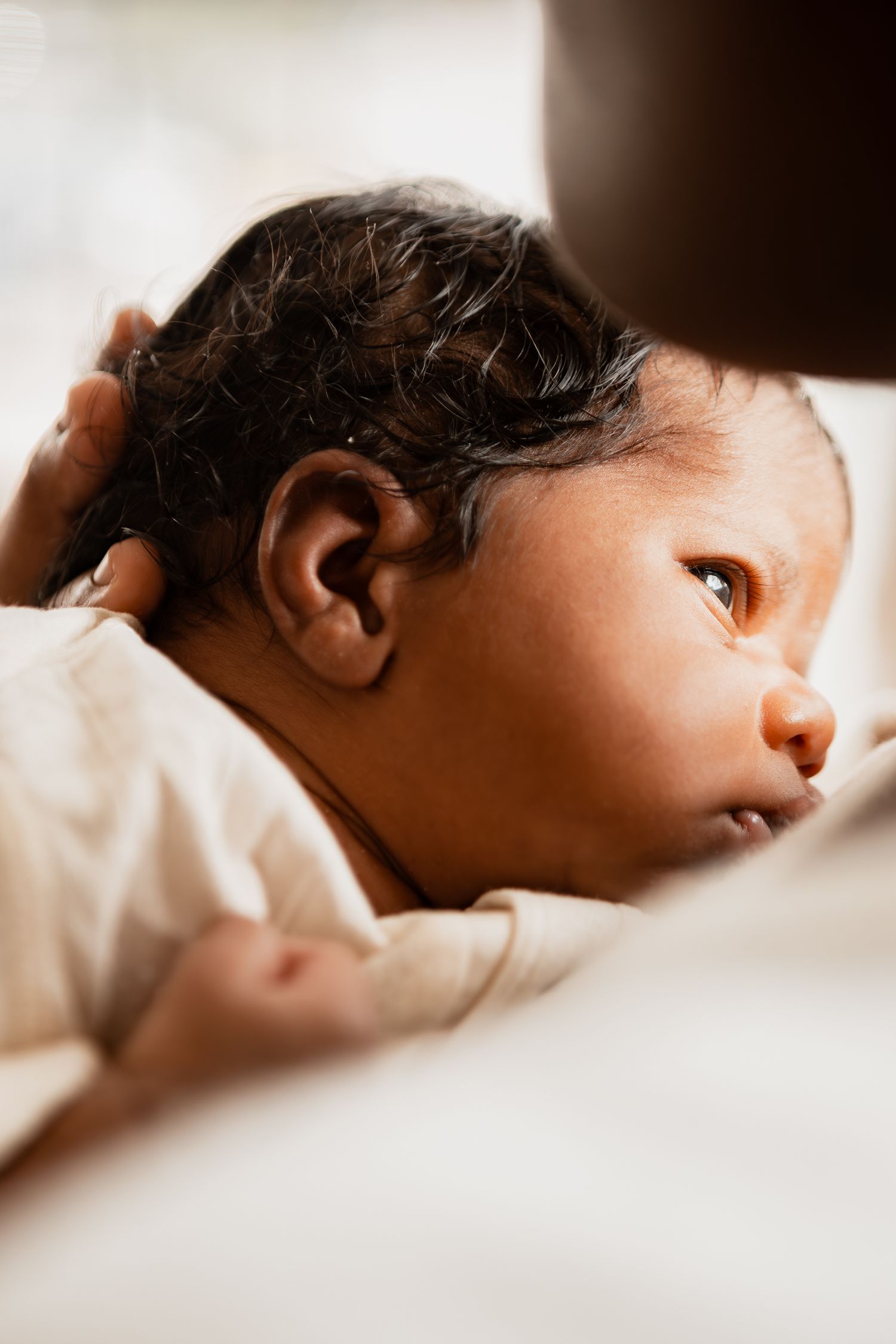 Artistic profile view of a sleeping baby in soft sepia tones showing peaceful innocence and tranquility.