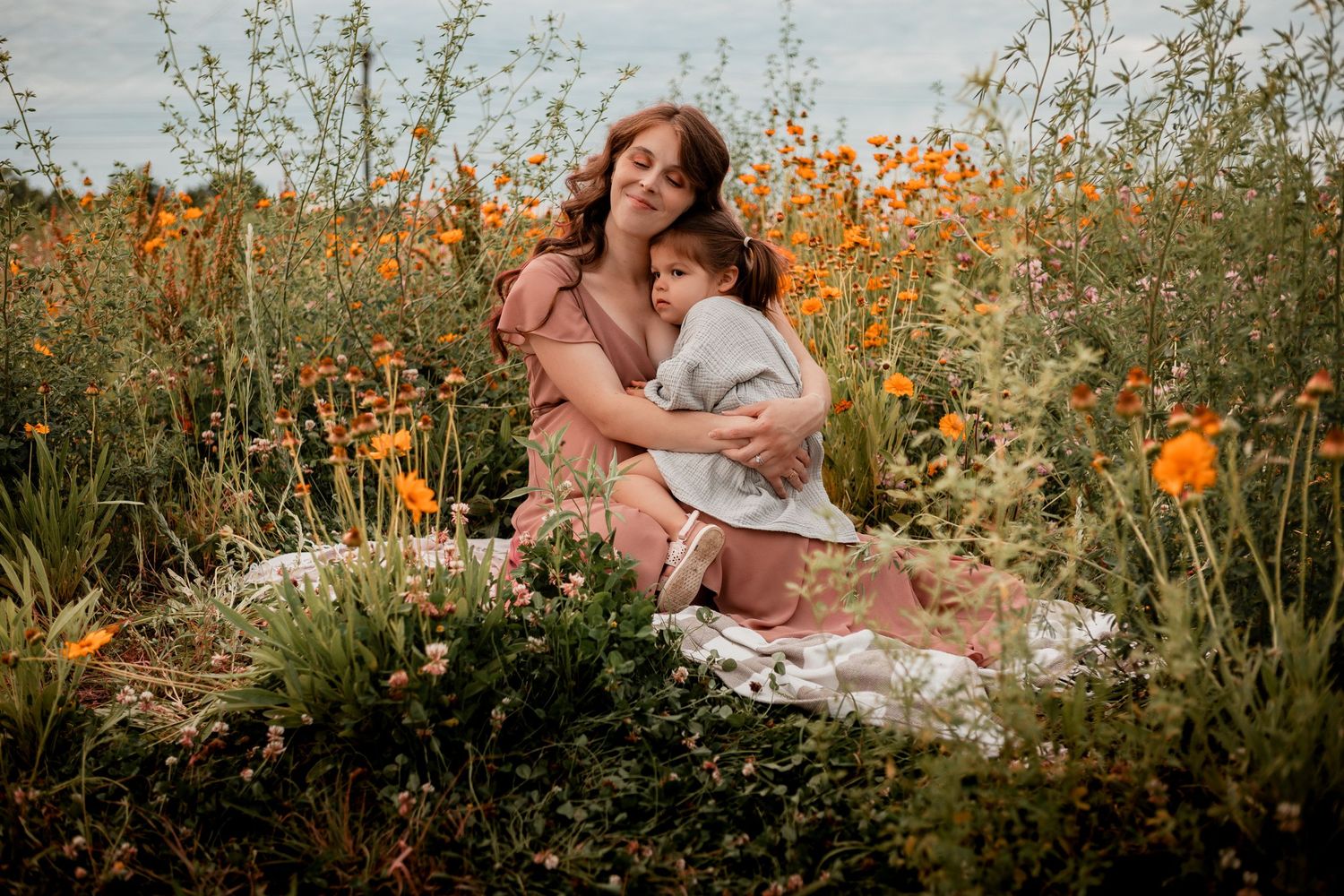 A romantic outdoor scene in a garden with orange poppies and wildflowers during golden hour sunset.