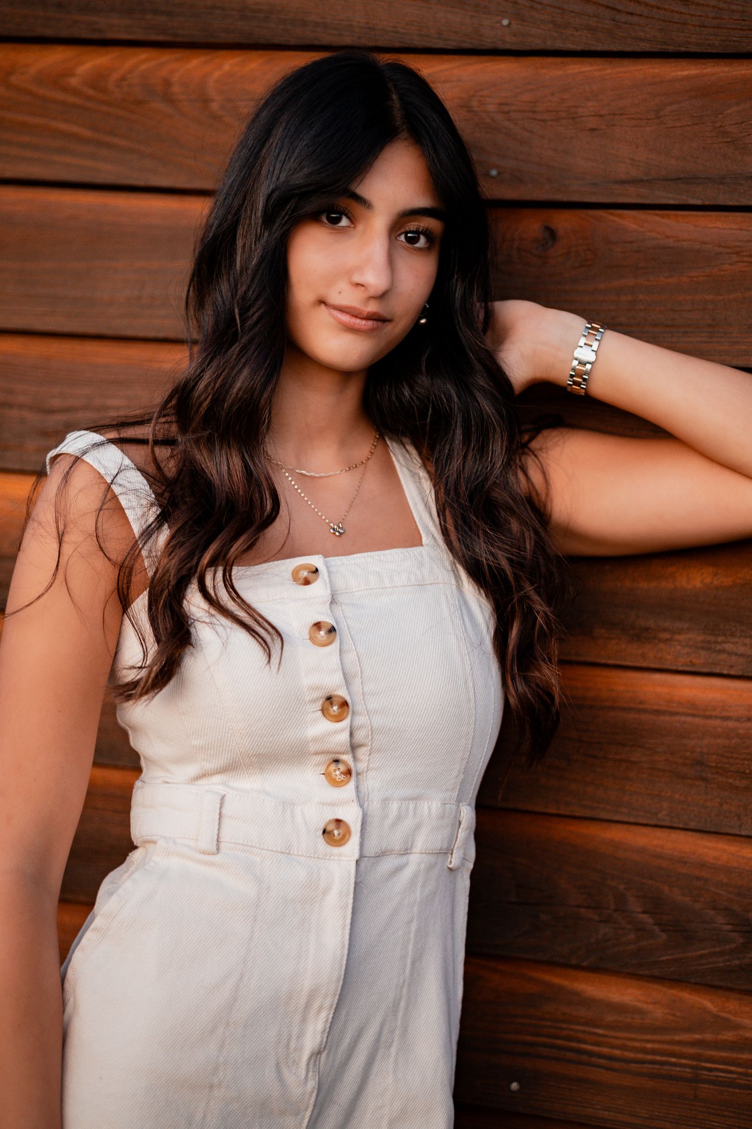 Portrait sequence showing a white sleeveless top with wood panel background in warm lighting.