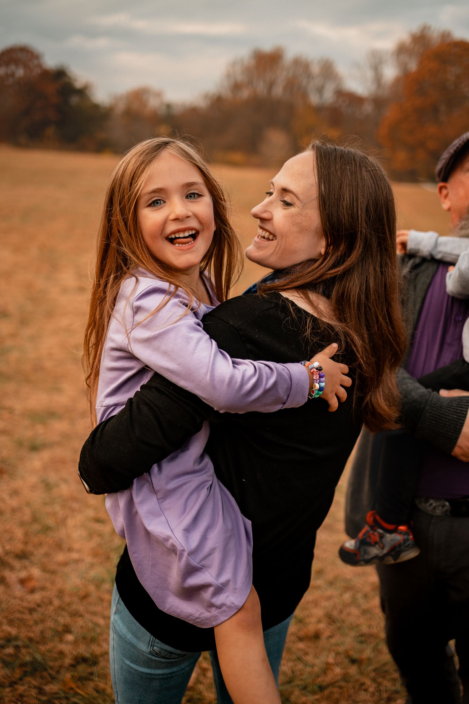 A heartwarming sequence shows two people sharing joyful laughter and embraces in an autumn field at sunset.