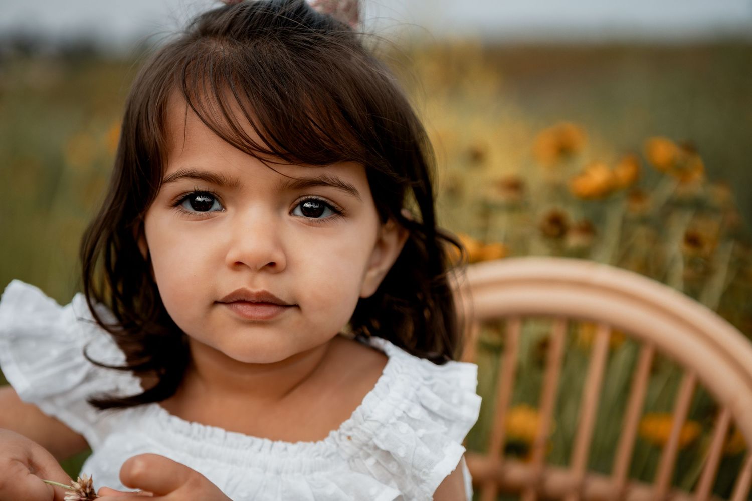 Four sequential photos show a child in a white lace dress outdoors against a blurred autumn background.