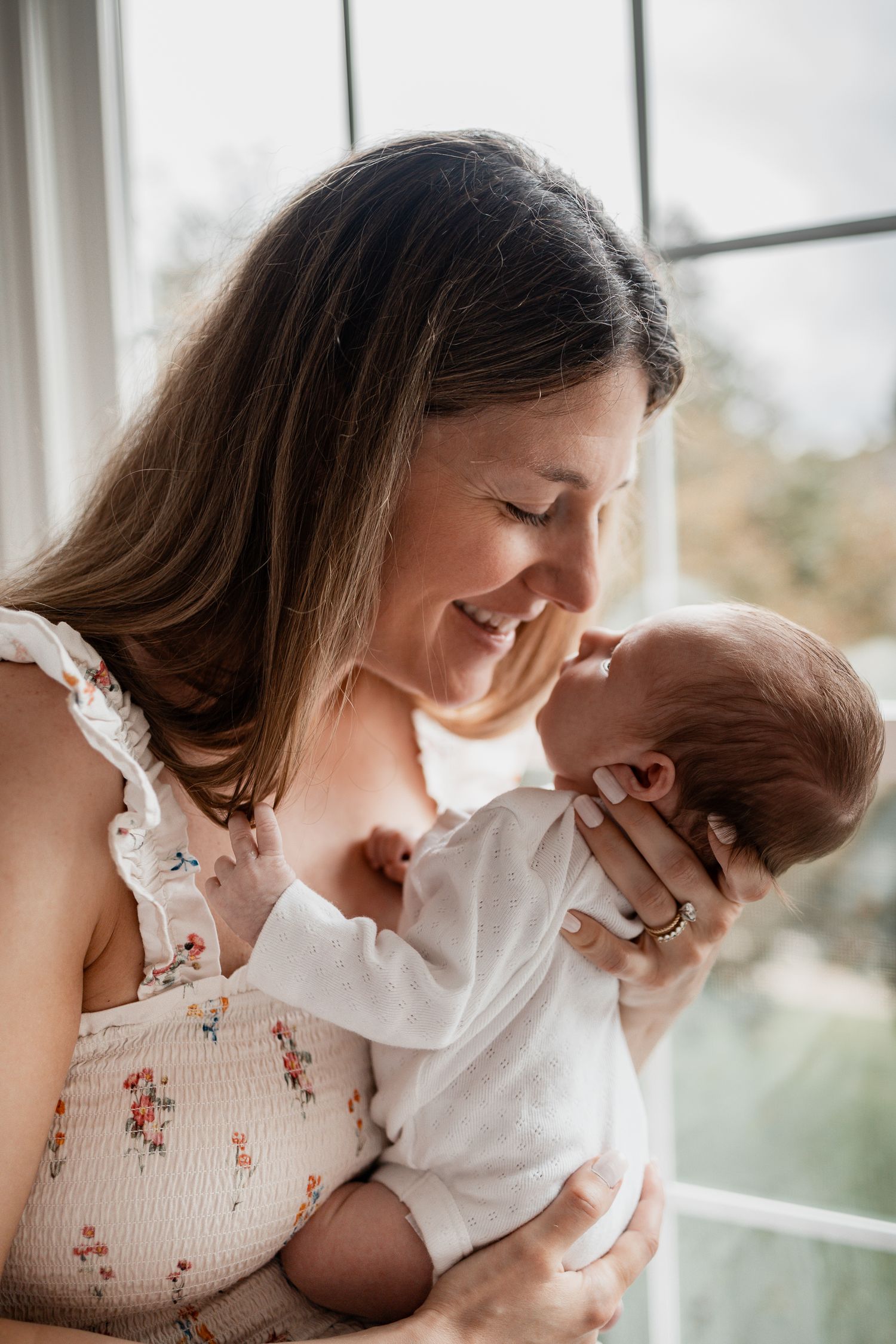 A heartwarming series of photos showing a mother bonding with her infant by a bright window.