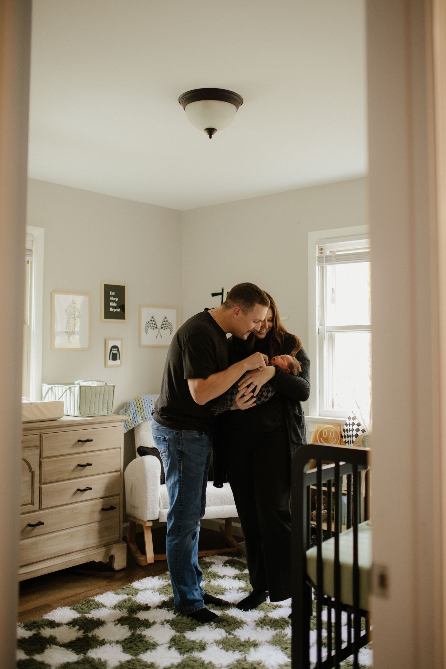 Wide angle view of a family sharing tender moments in a bright nursery.