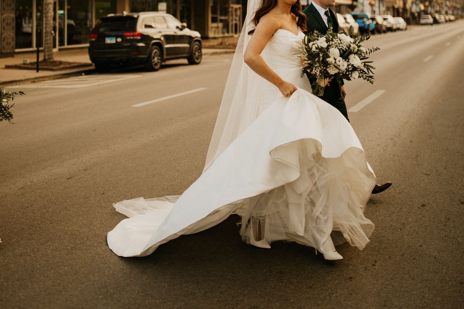 A romantic sepia-toned wedding photo series showing a couple dancing and twirling in an urban street setting.