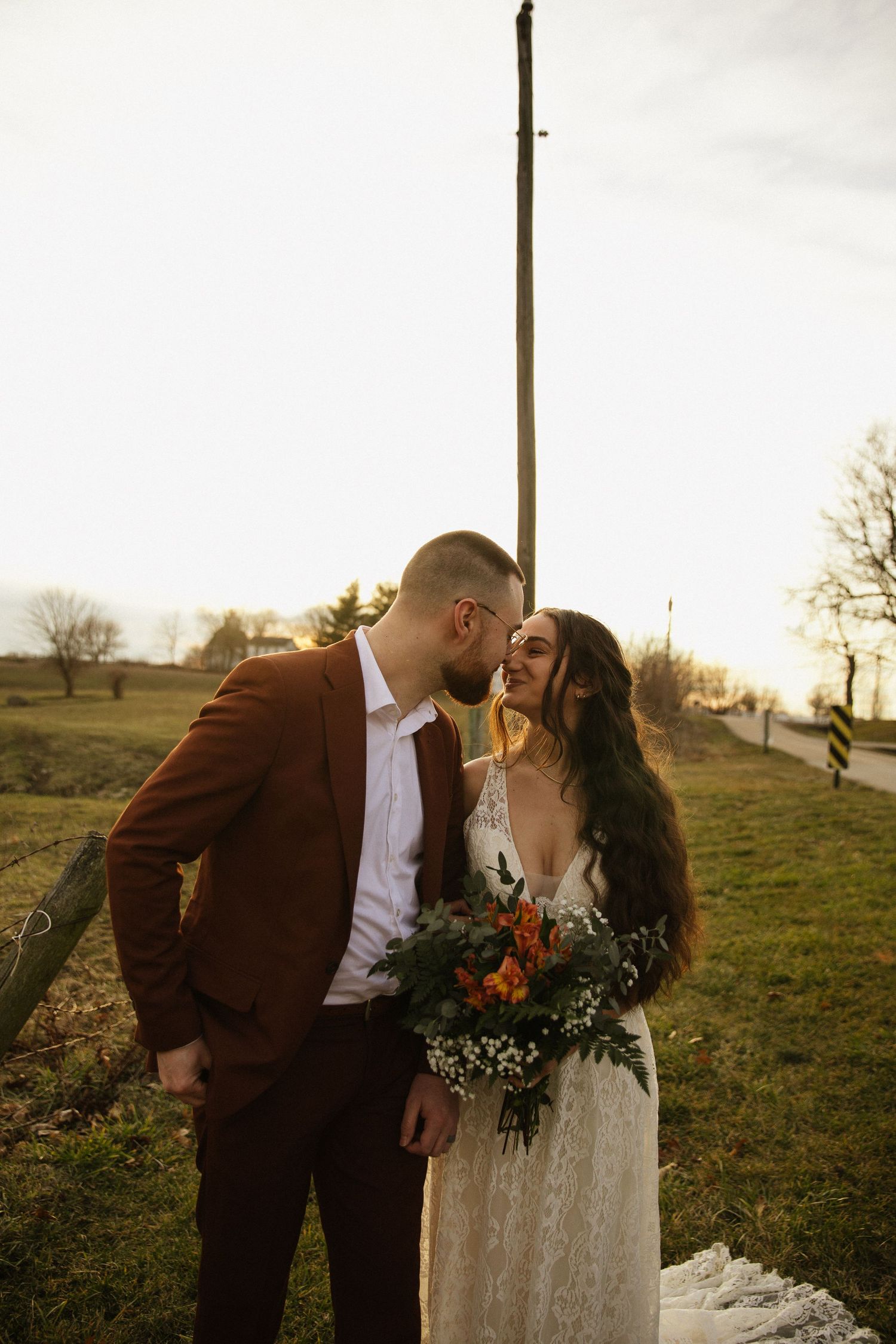 A romantic sunset moment captured in a rural field setting.