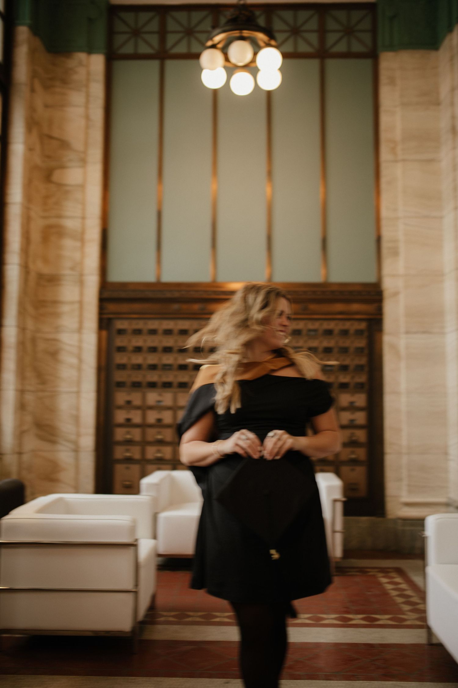 Dancing figures in motion captured in an elegant indoor venue with vintage lighting.