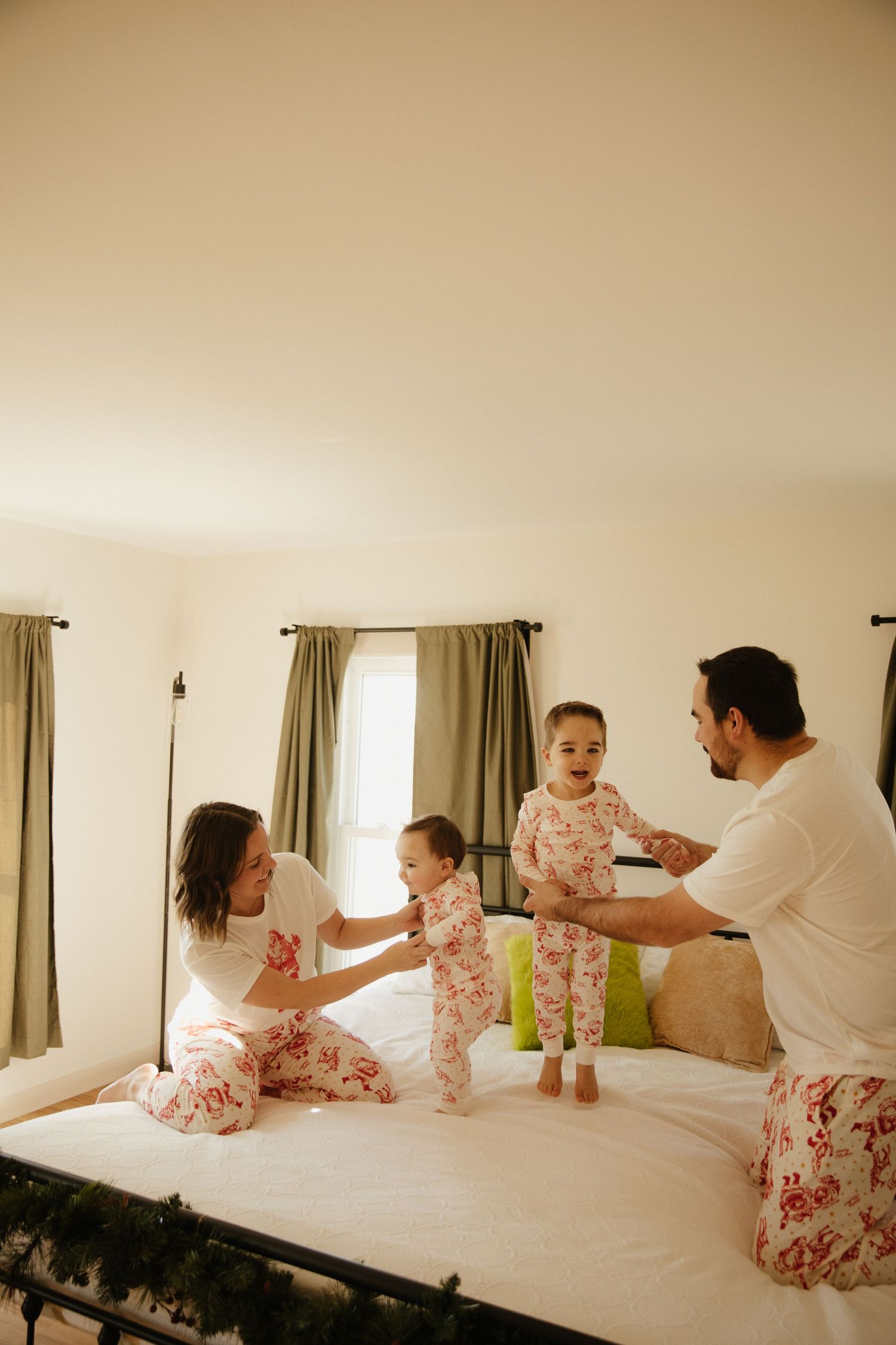Playful family interaction captured during an indoor lifestyle photoshoot on a bed.