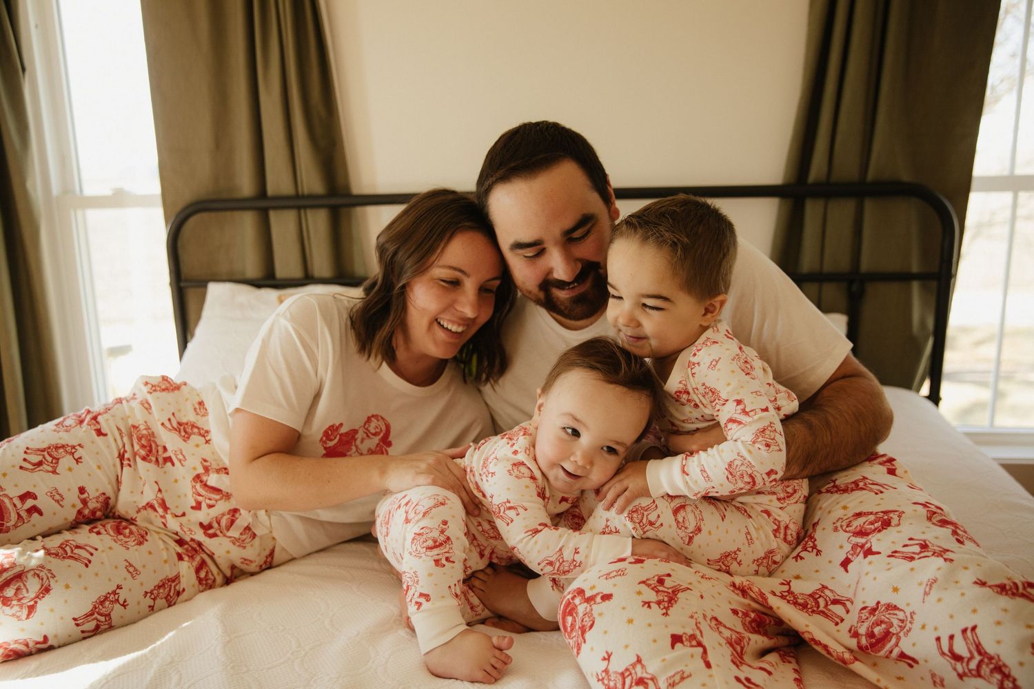Family sharing tender moments together on a cozy bed with floral bedding.