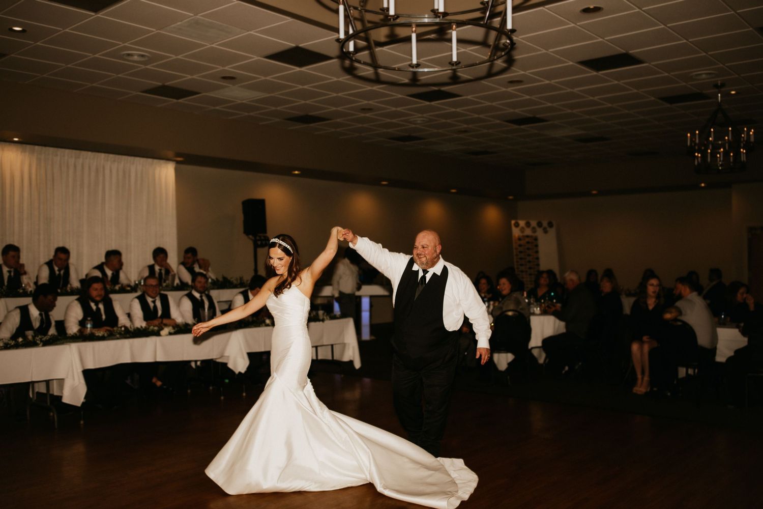Wedding reception dance floor with couples dancing under dimmed lighting.