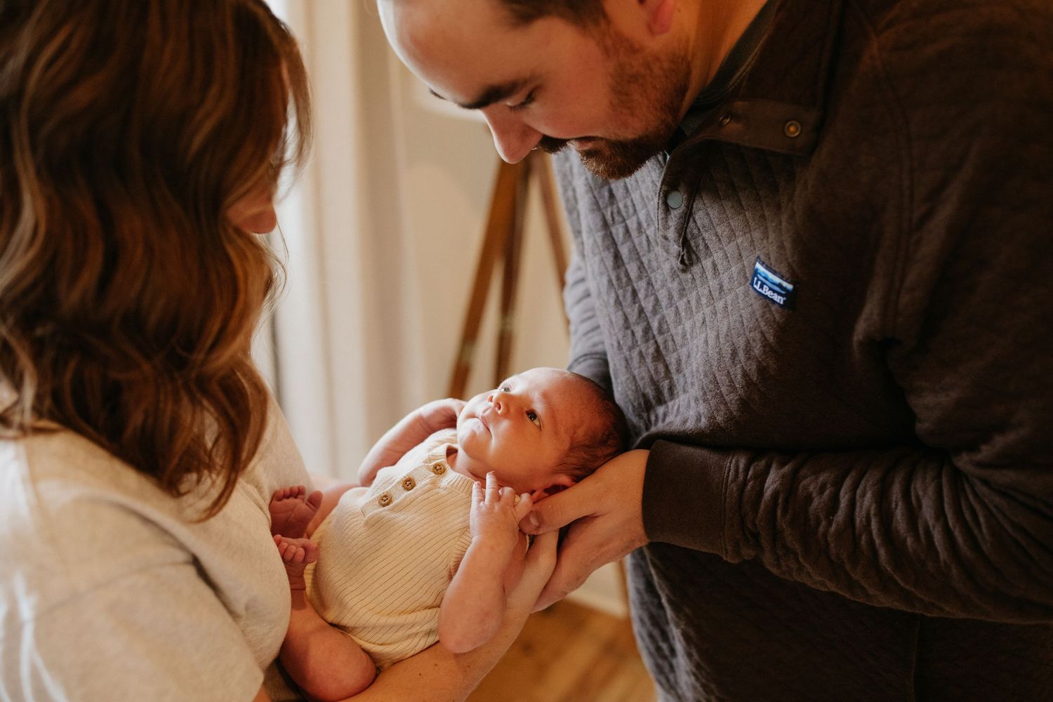 Tender moment with newborn baby in warm indoor lighting.