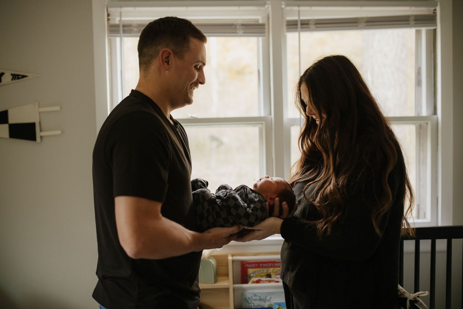 A couple shares an intimate moment in their home near a window.