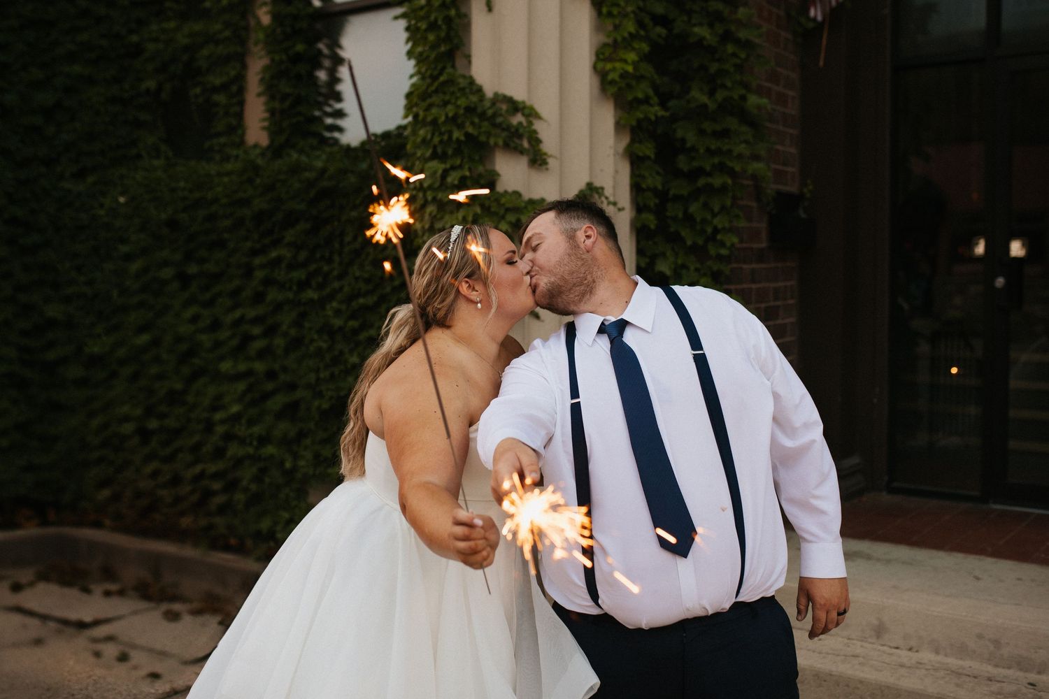 Romantic sparkler exit celebration at night with wedding guests.