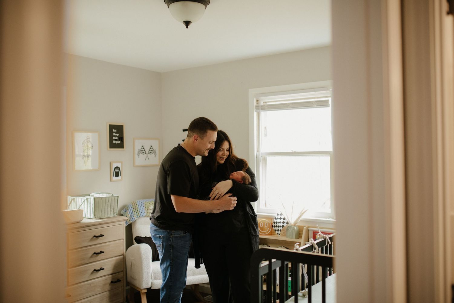 Intimate couple sharing a tender moment in a sunlit kitchen corner.