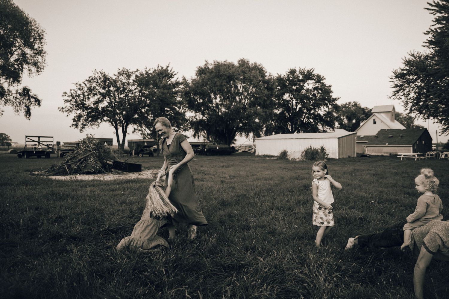 Vintage sepia photograph of children playing in a rural farmyard setting.