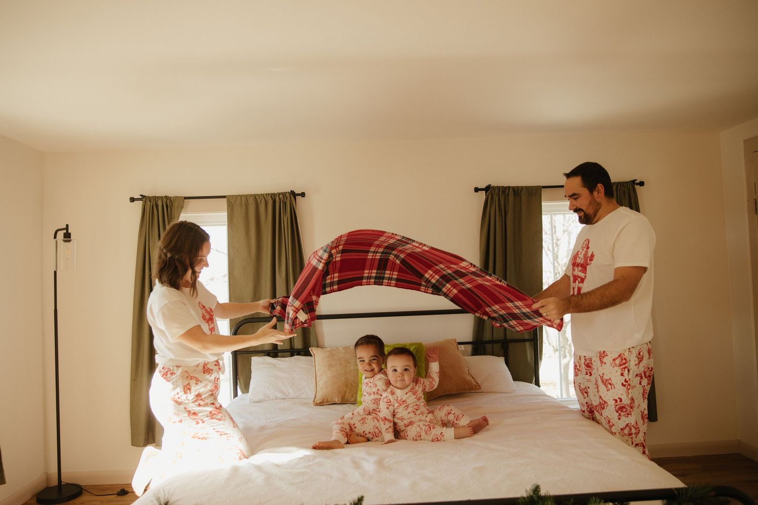 Family playtime captured in warm tones on a comfortable bed at home.