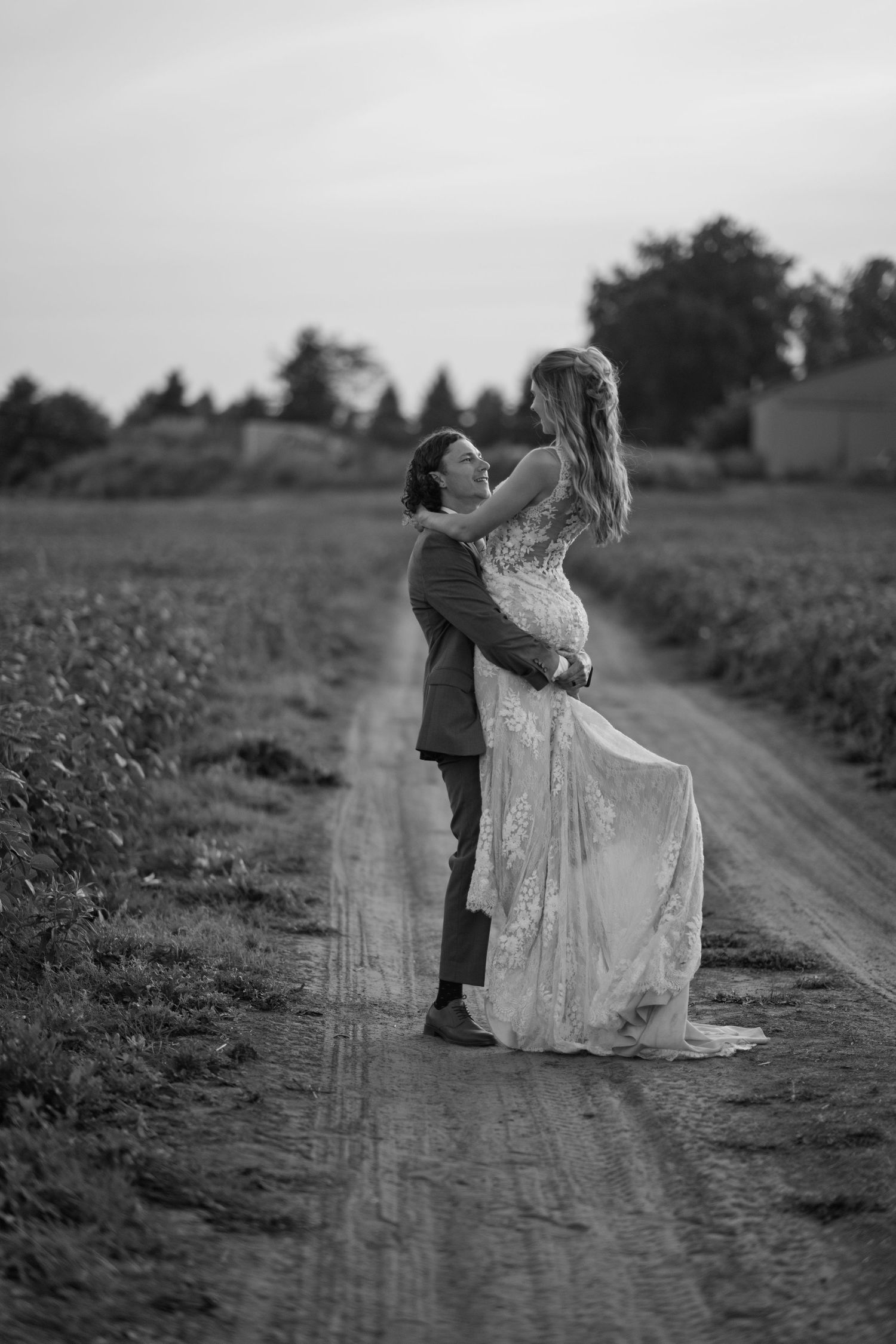 Black and white wedding portraits captured on a rustic country road.