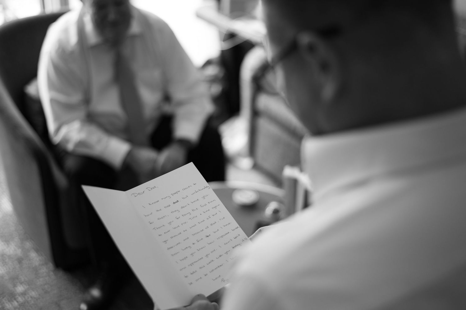 People seated at tables in a tent review documents during what appears to be a business meeting or workshop.