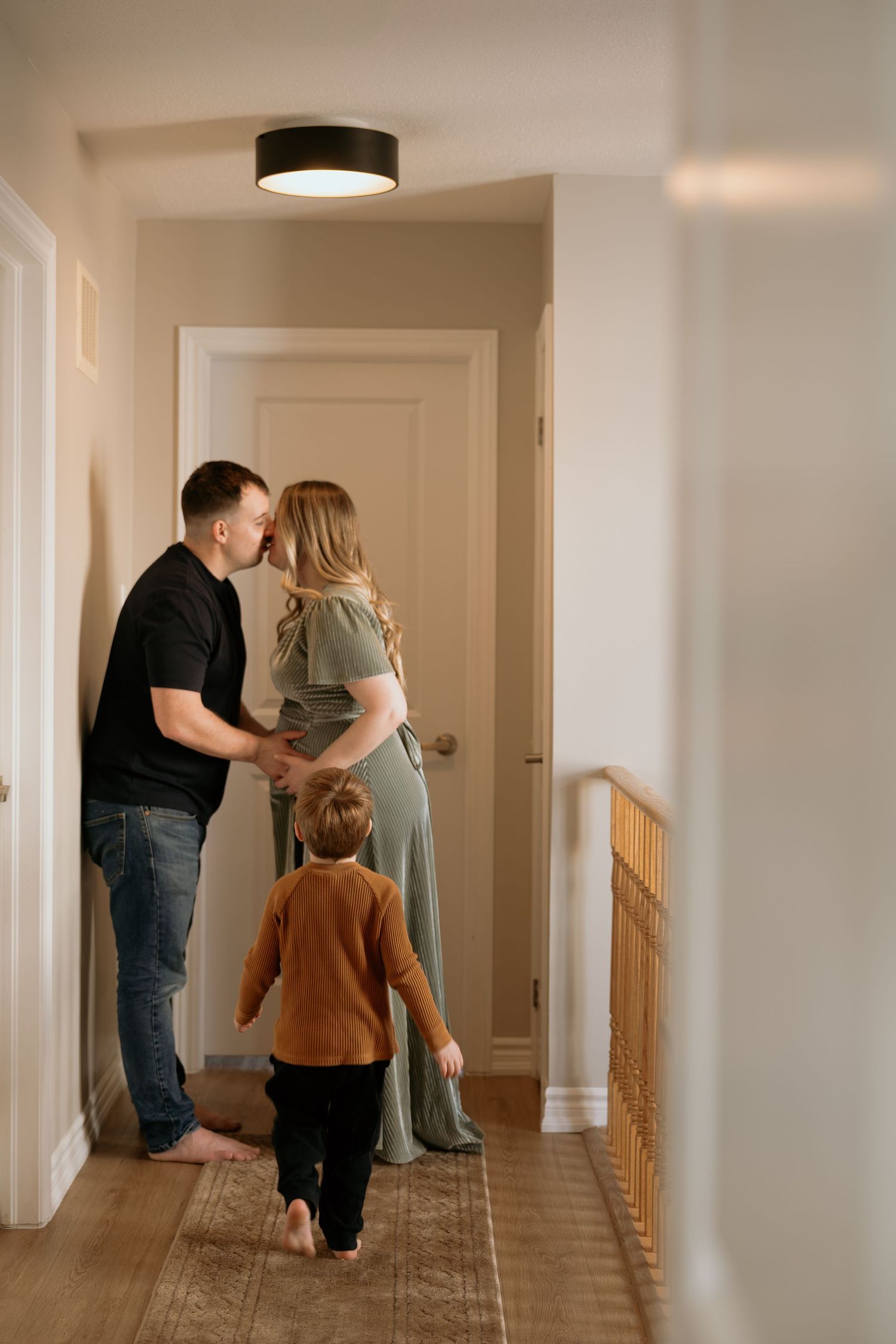 Family moment captured in a bright hallway of a modern home.