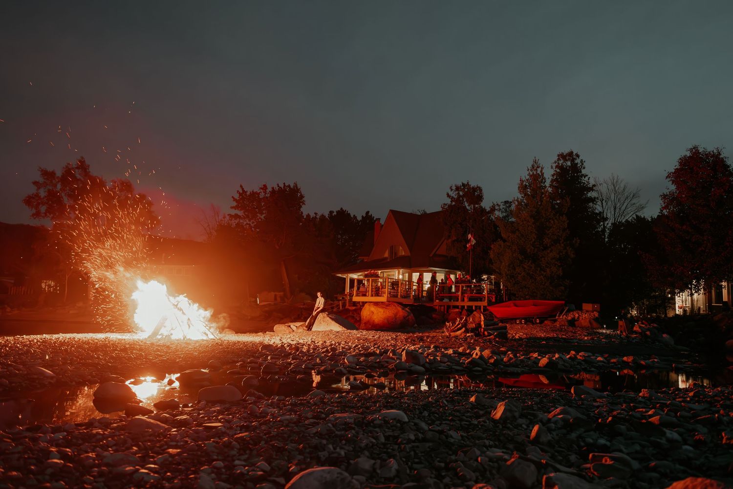 Dramatic nighttime landscape with bright fire displays creating an orange glow across the horizon.