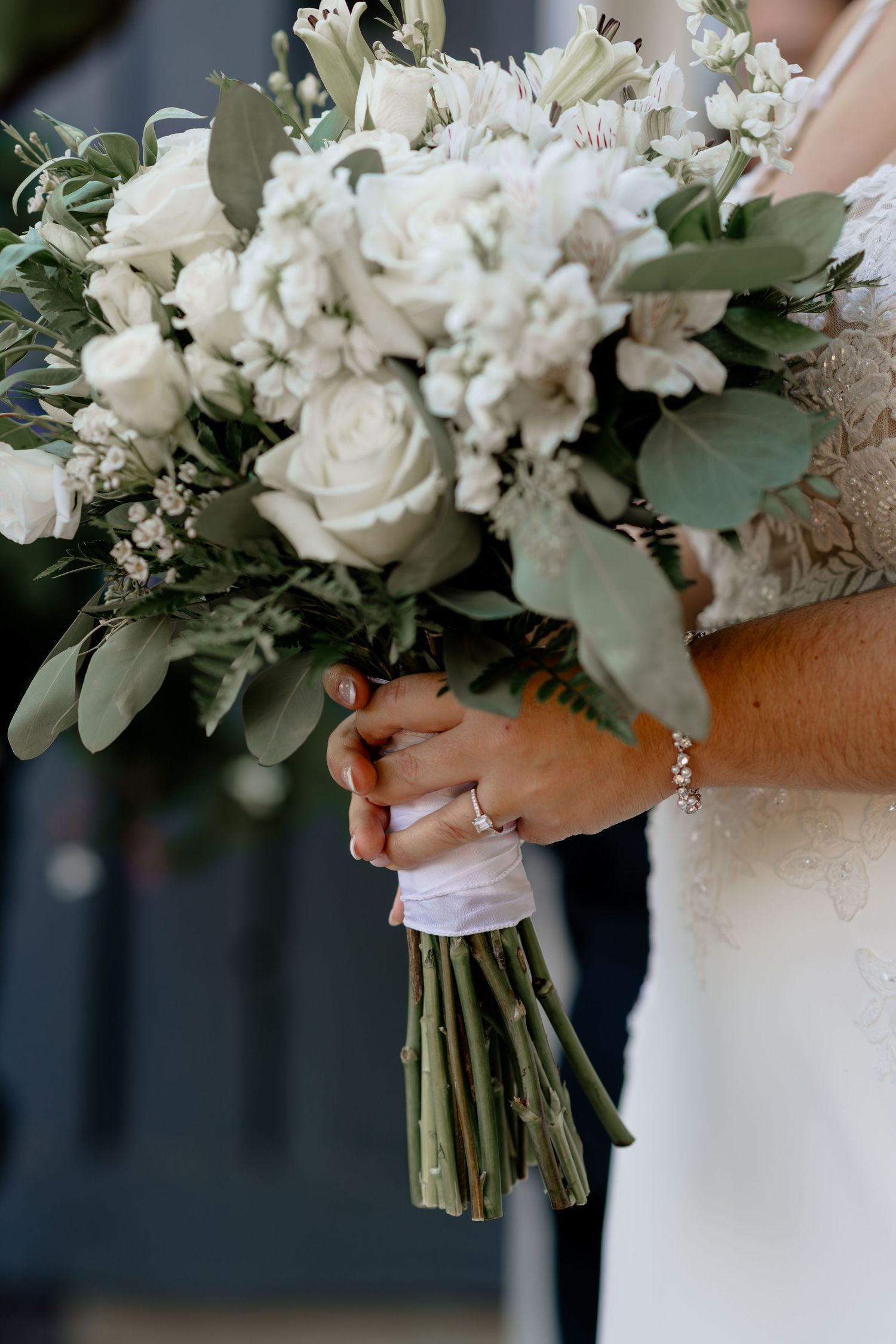 Close-up detail shots of elegant white floral wedding bouquets with roses, eucalyptus leaves and delicate greenery.