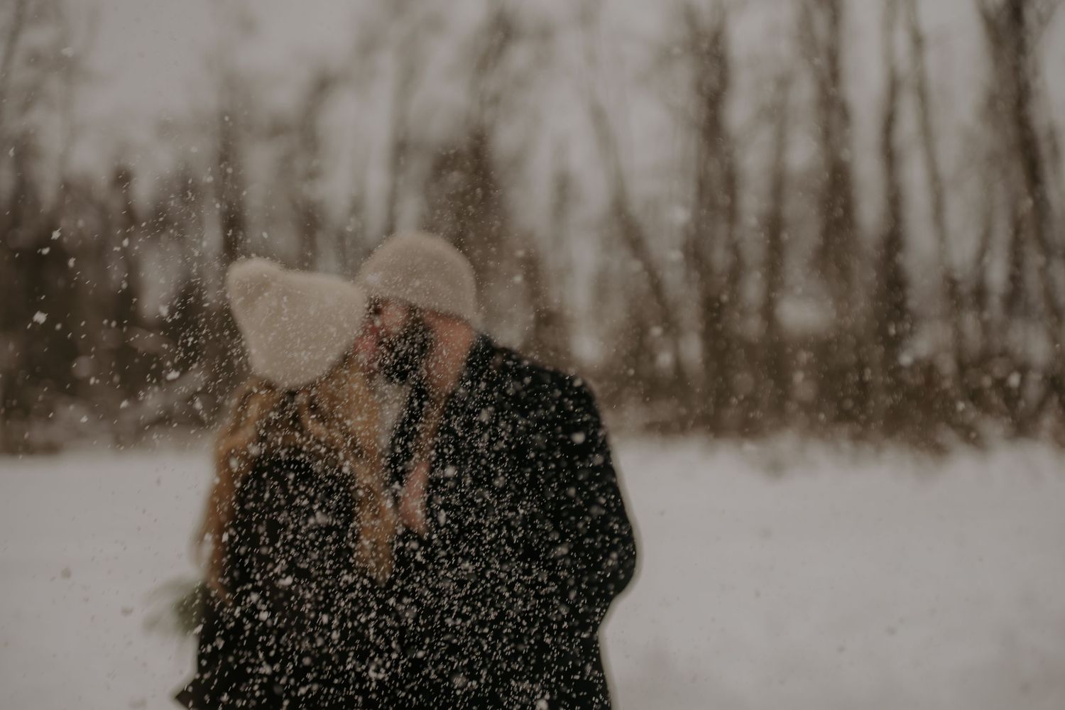 Romantic winter scene with snowflakes falling around a couple.