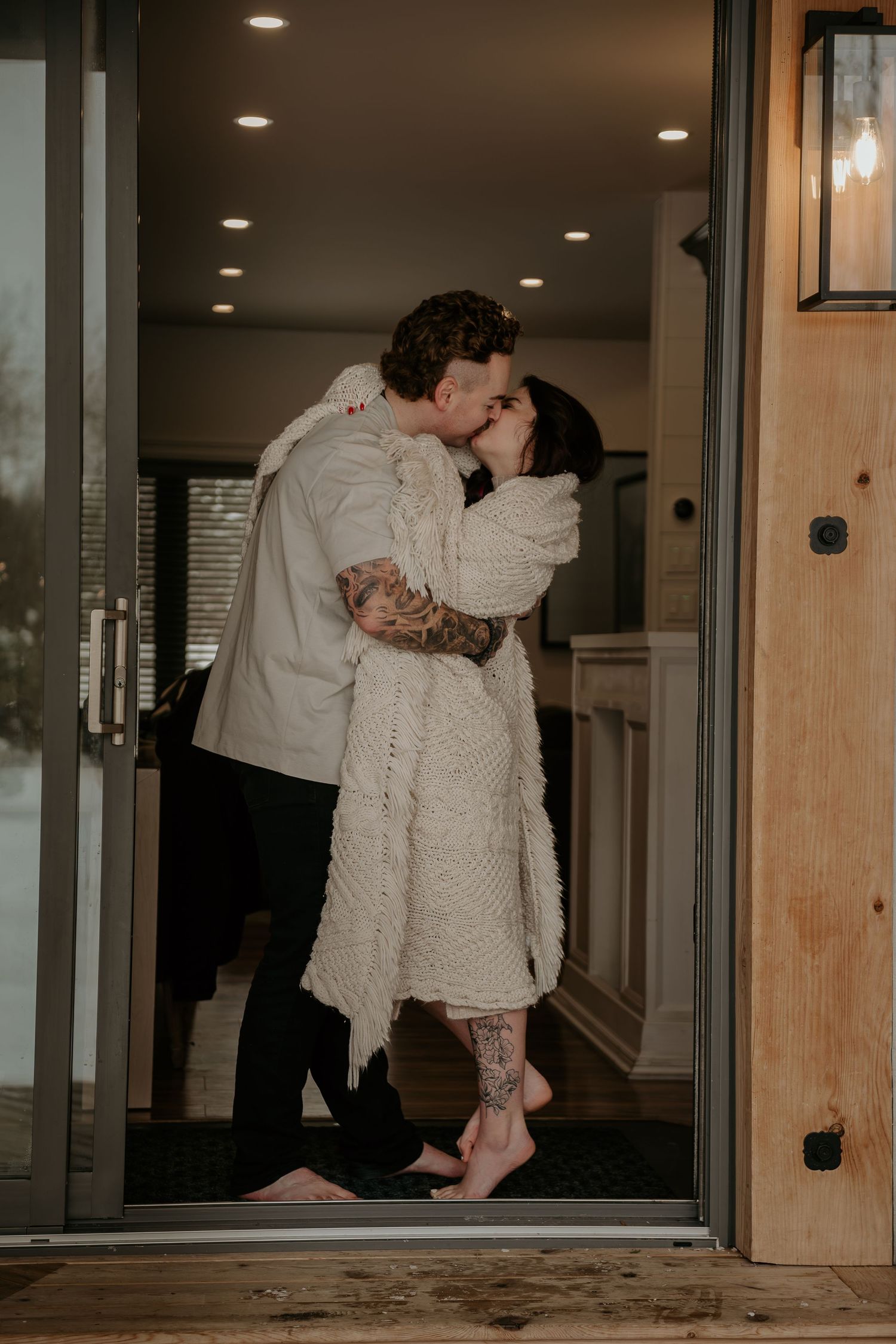 Couple in white clothing sharing an intimate moment by a window.
