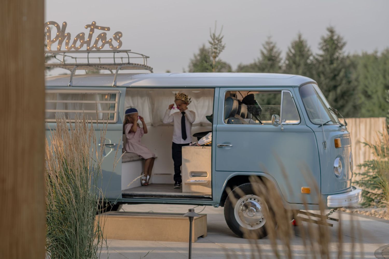 A vintage blue VW van parked at an outdoor wedding venue.