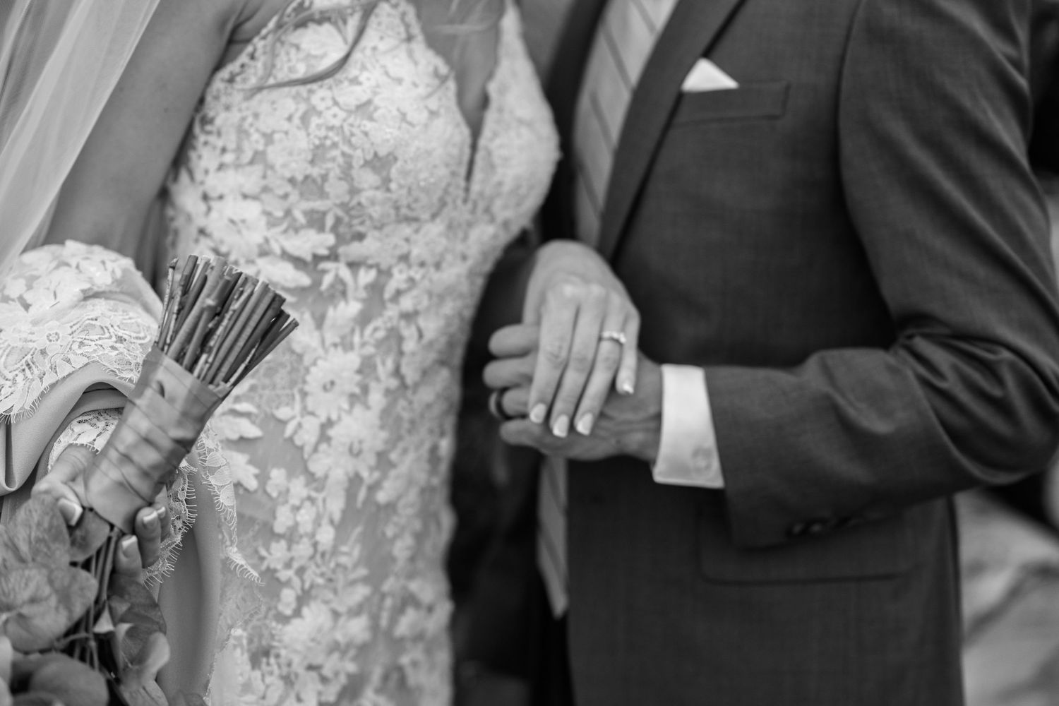 Black and white detail shot of wedding dress lace and formal attire.