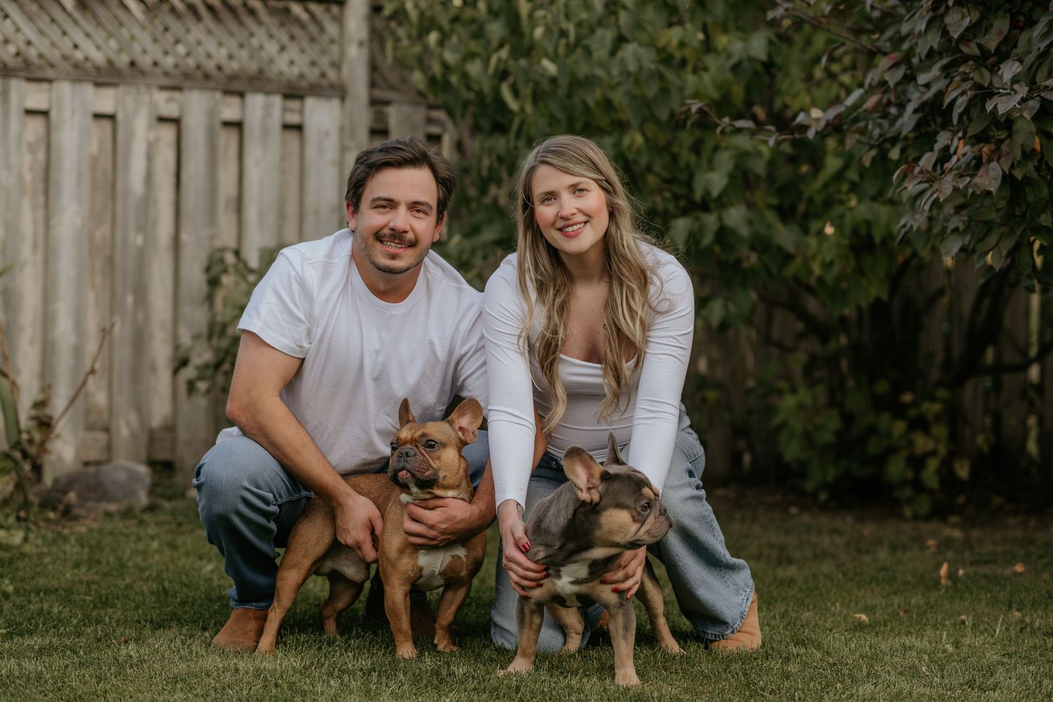 Family photoshoot in backyard features brown dog and casual attire.