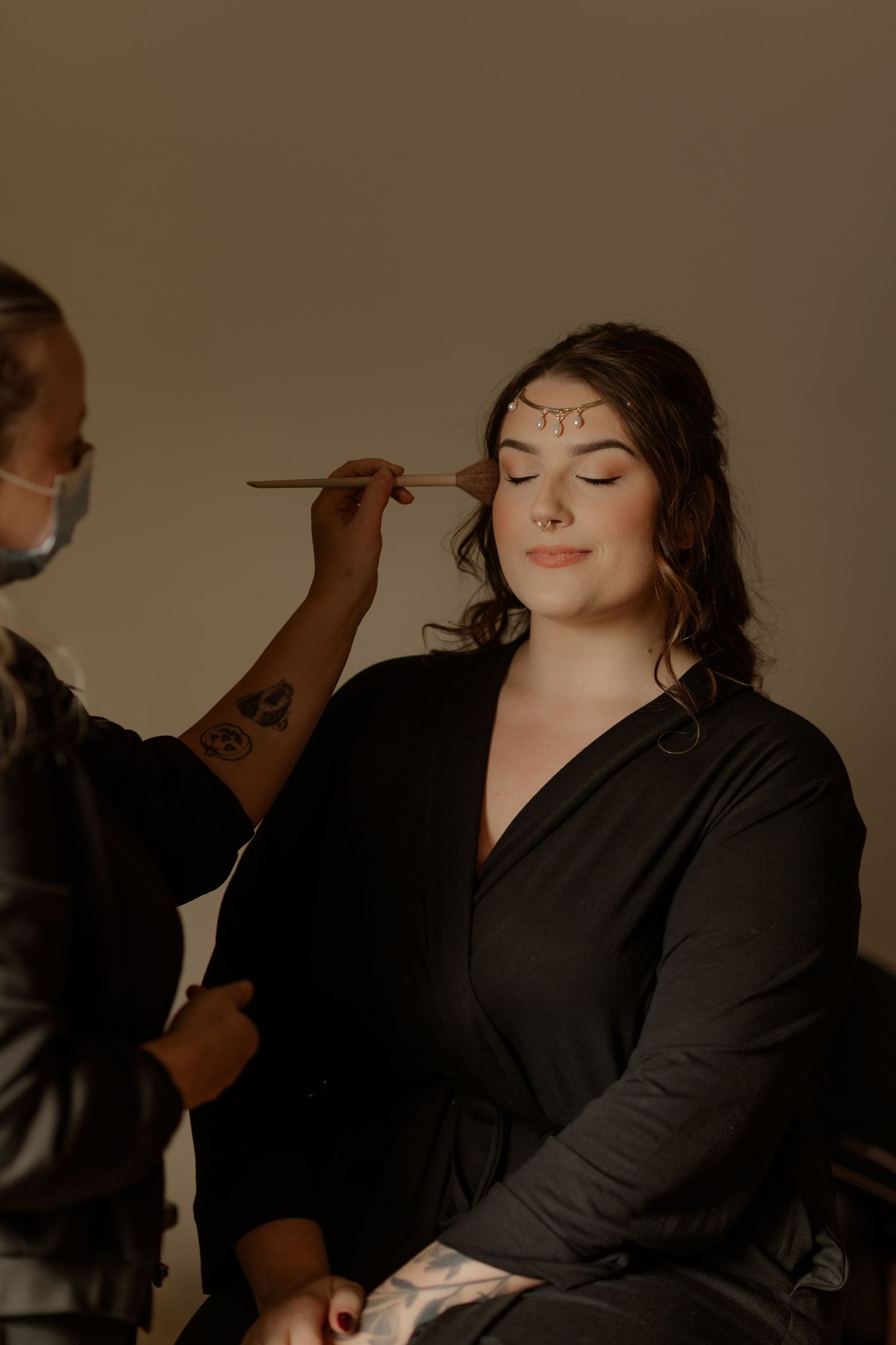 Behind the scenes makeup session with brushes and tools being applied in a professional setting.