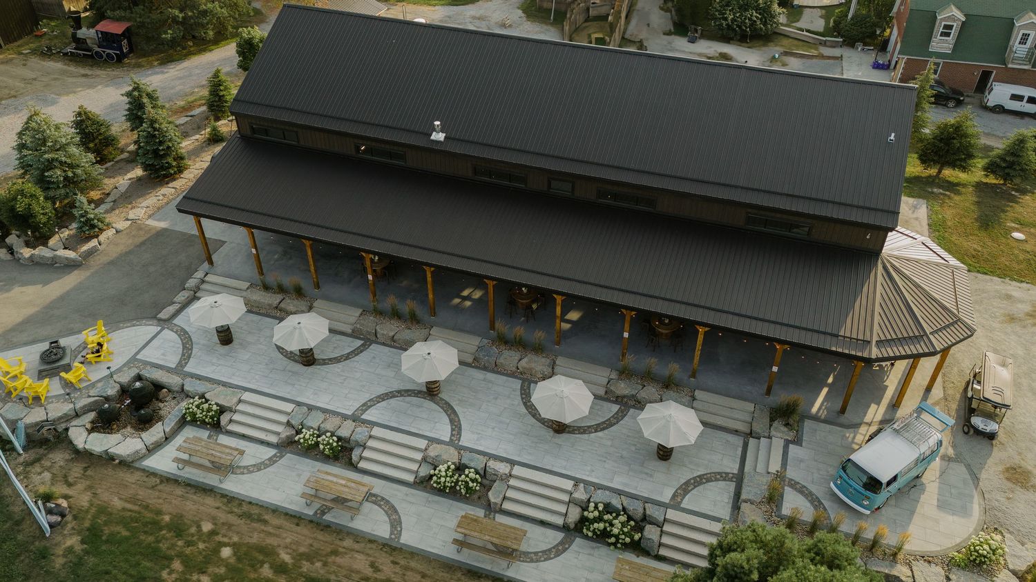 Aerial view of a rustic wedding venue with outdoor seating and covered pavilions.