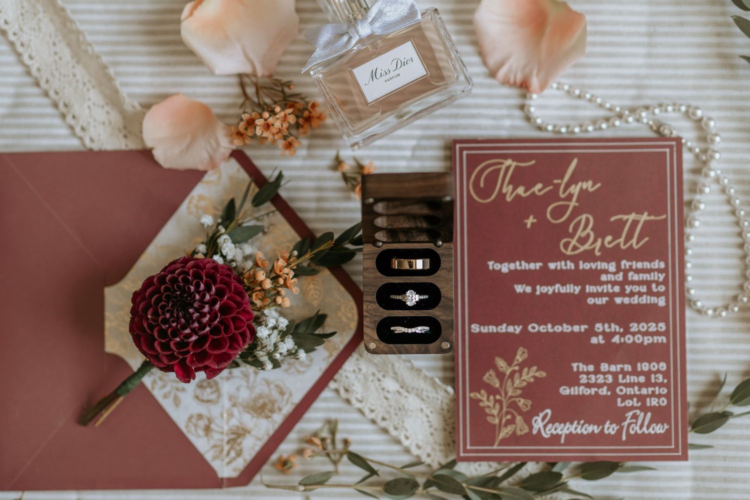 Elegant wedding invitation suite in dusty rose and burgundy with floral accents and calligraphy details.