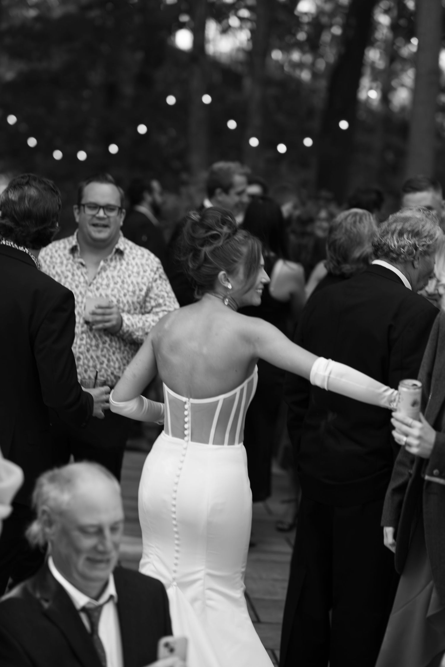 Wedding reception dance floor filled with guests under twinkling lights.