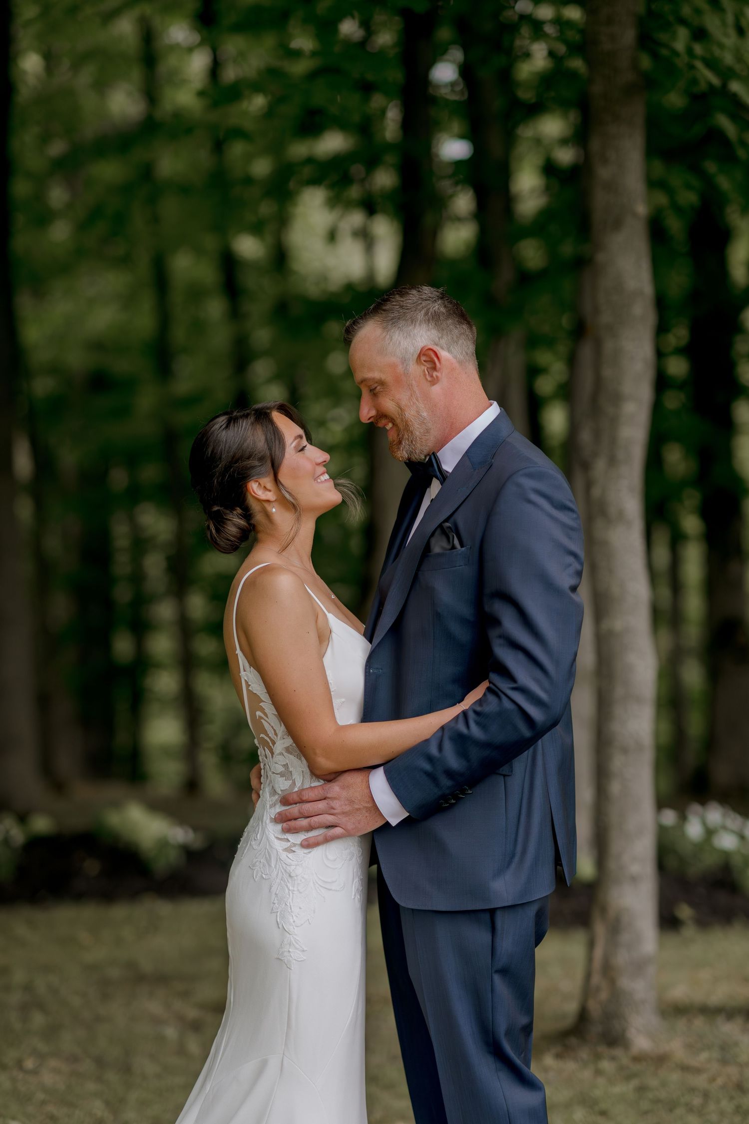 Romantic wedding moment captured in a serene forest setting.